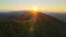 Amazing mountain landscape. Dark spruce woods illuminated with yellow setting sun. Bright colorful sunset in wild