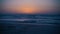 Amazing mystical bloody sunset on the sea. Clear sky. The calm sea with small waves. Waves rippling over sand. View from