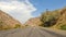 The amazing nature of Kyrgyzstan. Serpentine mountain roads. View of the paved road, colorful rocky mountains