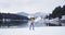 Amazing nature view of a big lake and mountain with snowy forest , very happy tourist running with a map in front of the