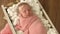 Amazing newborn baby girl sleeps wrapped in a pink blanket