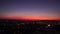 Amazing night panoramic view with sunset over the city. Red-violet sunset sky over the city. You can see how cars are driving in t