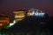 Amazing night view of beautiful fabulous glowing restaurant standing on top of hill with watermill