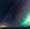 Amazing panorama of scenic vertical Milky Way stars and galaxies and Aurora Borealis glow under starry sky above horizon line,