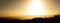 Amazing panorama silhouette of paragliding in landscape with mountains at sunset and yellow sky