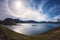 Amazing panoramic landscape, Highlands of Iceland with lake in volcanic mountains, blue cloudy sky and solar halo, Iceland