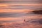 Amazing pink sky and mountain all around. Friends having fun on top of the mountain while skiing/snowboarding. Breathtaking sunset