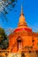 Amazing red pagoda with the Buddha image against blue sky background at Wat Khao Rup Chang Temple. Located along the Phichit-Tapha