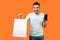 Amazing sales in online shop! Portrait of happy buyer, brunette man holding shopping bags and cellphone. isolated on orange