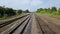 Amazing scenery of empty long railways laying along green line of forest trees.