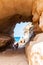 Amazing seascape view from unique sea cave on famous Rotonda beach. Tourists walking through the grotto, resting on small beach.