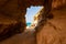 Amazing seascape view from unique sea cave on famous Rotonda beach. Tourists walking through the grotto, resting on small beach.