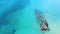 Amazing shipwreck in turquoise exotic sea. Old ship lying abandoned in the sea after crash. Aerial view. Touristic attraction