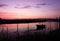 Amazing shot of a colorful sunset with a reflecton on the water and a fishing boat