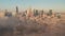 Amazing shot of downtown panorama coming out from dense fog. Group of high rise buildings lit by morning sun. Warsaw