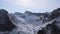 Amazing shot from drone of mountain range peaks covered in white snow. Aerial view through fog of hills on morning of