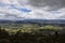 Amazing shot at high peak view of a mountain landscape, green country fields and mountain valley