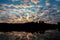 Amazing shot of a reflective water surface on a forest silhouette and a sunset sky background