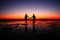 Amazing silhouette of couple walking hand in hand on sunset background