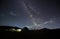 Amazing starry night sky in the mountains and tent at campsite