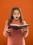 Amazing story. Girl hold book orange background. Child show book notepad. Book store. Free book available to read