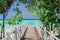 Amazing , stunning view of wooden old bridge leading to the beach through tropical beautiful garden