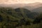 Amazing summer mountain landscape - green folded mountain ridges in early morning sunlight with soft pastel pink mist, fluffy.