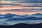 Amazing sunrise high in the mountains with blue and pink mountain silhouettes