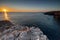 Amazing sunrise over the rising cliffs and rocks in Malta, with spectacular colors in the sky and reflections of the sun in het Me