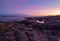 Amazing sunrise polar landscape with a white snow ridge of mountains behind the rocky mountains and a cliff. Wonderful mountain