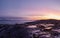 Amazing sunrise polar landscape with a white snow ridge of mountains behind the rocky mountains and a cliff. Wonderful panoramic