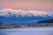 Amazing sunrise polar landscape with white snowy mountain range on the horizon. Wonderful mountain landscape on the Barents sea