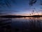 Amazing sunset, with beautiful sky reflections in the water of Hancza lake. View through the spiderweb full of death insects.