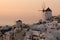 Amazing Sunset over white windmills in town of Oia and panorama to Santorini island, Cyclades, Greece