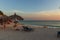 Amazing sunset on sandy beach and Atlantic Ocean. Sun beds and umbrellas on turquoise water and blue orange sky background.