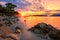 Amazing sunset seascape, beauty of nature. Scenic view of the sea, rocky seacoast and sandy beach, golden colored sky and sun