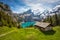 Amazing tourquise Oeschinnensee with waterfalls, wooden chalet and Swiss Alps in Berner Oberland
