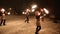 Amazing tribal fire show dance at night on winter under falling snow. Dance group performs with torch lights and