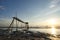 Amazing tropical sunset background, wooden water pump tower on the muddy beach