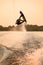 amazing view of active strong male rider holds rope and making extreme jump showing trick with wakeboard.