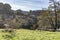 Amazing view of the ancient medieval village of Rupit from a field with old iron wheels trailer and a tractor.Traveling