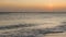 Amazing view of beautiful sunset on Atlantic ocean. Rolling waves, swimming pelican birds on orange horizon background.