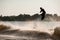 amazing view of guy holding rope and jumping high with wakeboard over water