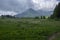 Amazing view of Mount Cornetto in italian Alps, hill hidden in rainy clouds, greenery sourroundings with beautiful natural park