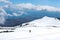 Amazing view from Mount Etna photographed with hikers going down on the snow and sea coast in the background. Magnificent clouds