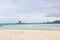 Amazing  view on the old aragonese tower in La Pelosa Beach. Beautifull beach with white sands, waves with foam and cloudly sky in