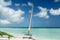Amazing view of sailboat resting on white sand Cuban beach on background of bright tranquil turquoise ocean water and deep blue sk