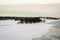 Amazing view of snowy coast of the frozen Baltic sea in winter. Forestry islands with little wooden houses.