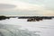 Amazing view of snowy coast of the frozen Baltic sea in winter. Forestry islands with little wooden houses.