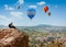 Amazing view with sport sitting girl and a lot of hot air balloons. National park Anatolia, Cappadocia, Turkey. Artistic picture
